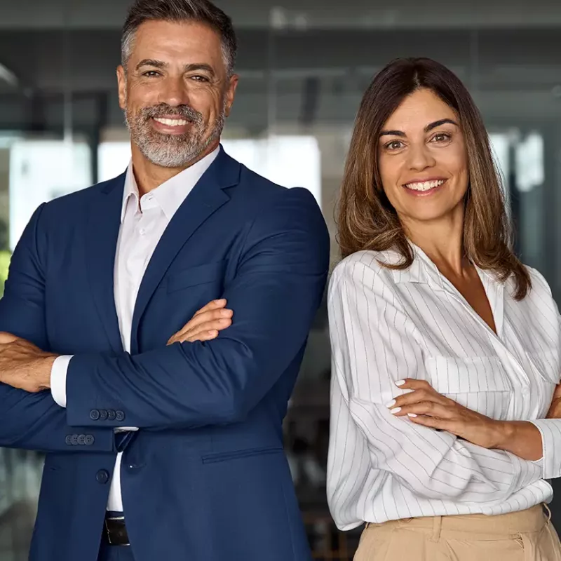 business man and woman standing back to back smiling at camera