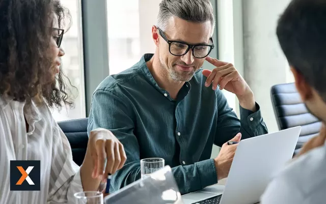 man with glasses sitting in front of computer thinking 