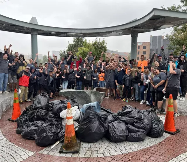 A large group of Xactlians in Denver with a pile of collected garbage during volunteering.