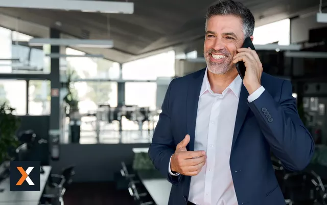 Business man standing talking on phone smiling