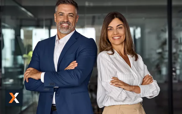 business man and woman standing back to back smiling at camera