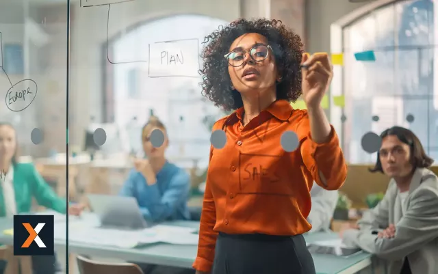 Business woman standing at whiteboard drawing