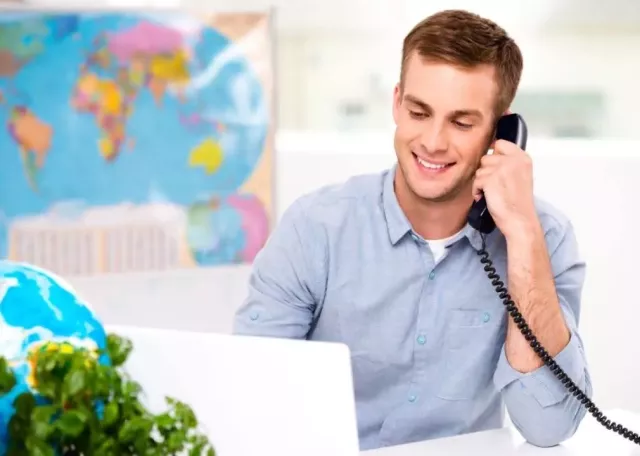 sales agent sitting at computer taking on the phone