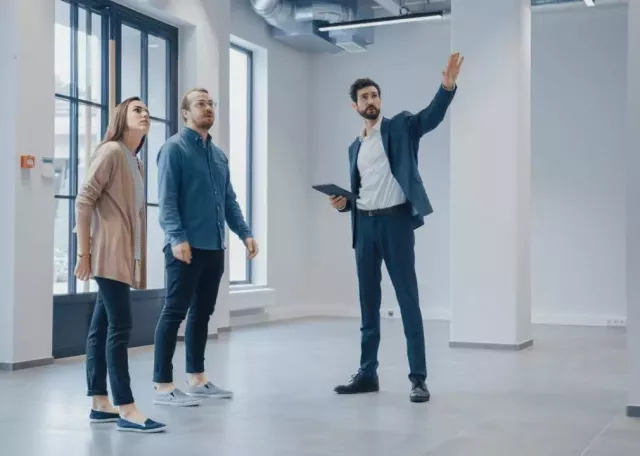 real estate professional showing a man and a woman a house