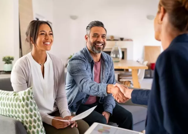 man and woman shaking hands with an insurance agent