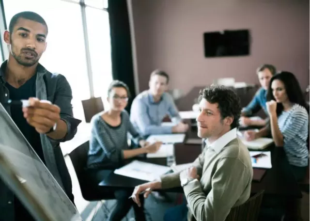 advertising sales agent talking to a group of people sitting at a table