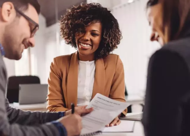 financial agent sitting and speaking with two clients