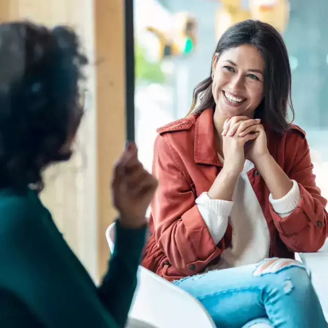 Two business women smiling and working together